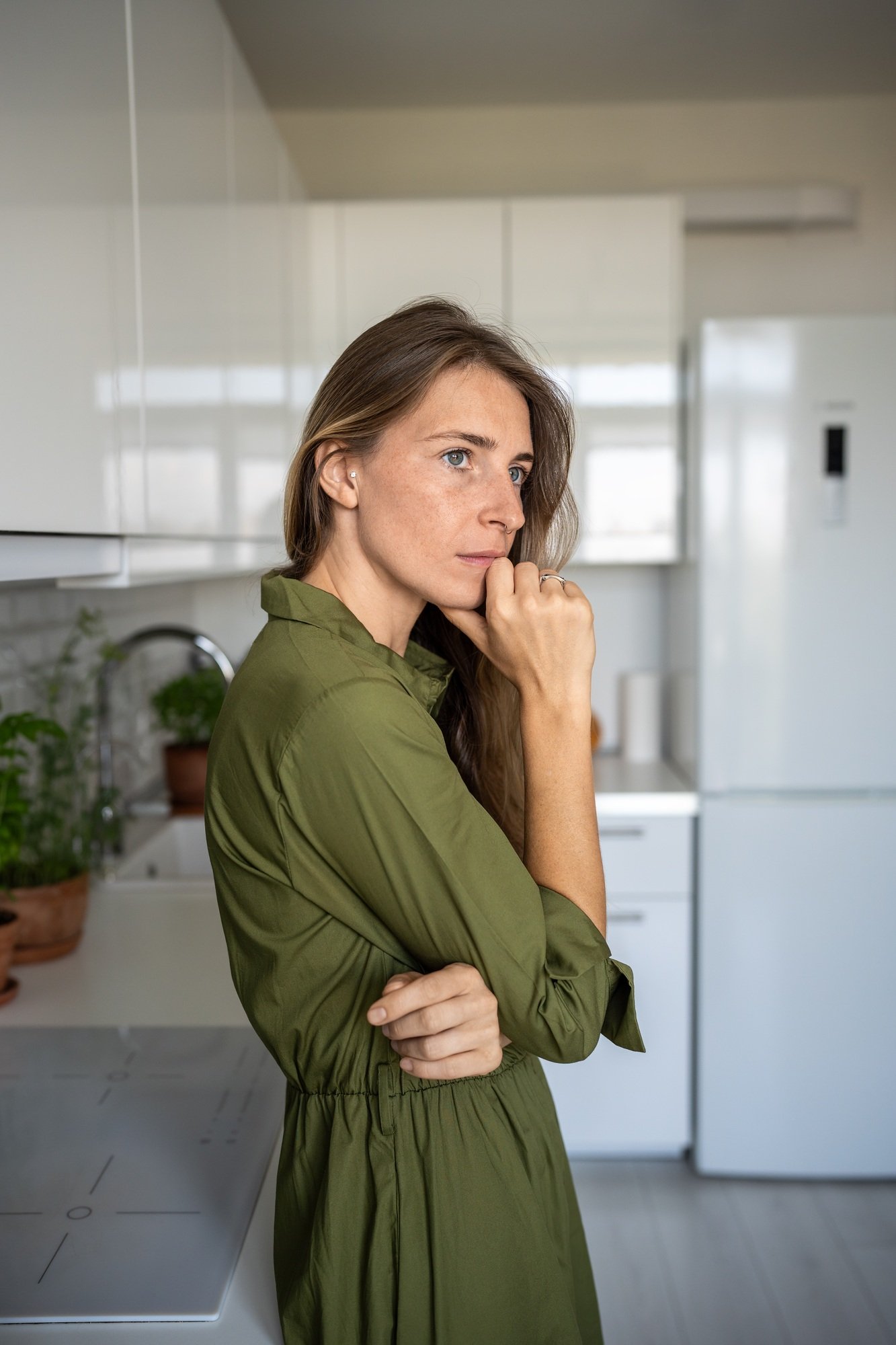 Depressed frustrated middle aged woman thinking about difficult problems standing at home in tension